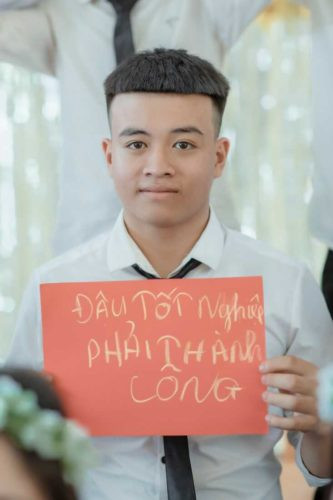 Ảnh bạn học sinh nam chụp với bảng kỷ niệm