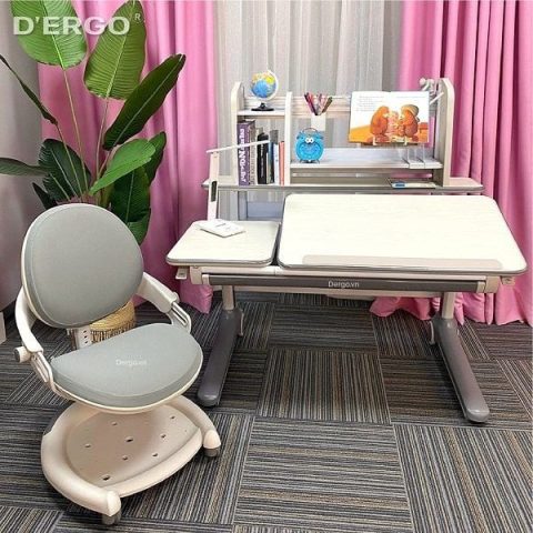 Bé gái ngồi học bài trên bàn học, chiều cao bàn học sinh tiểu học phù hợp