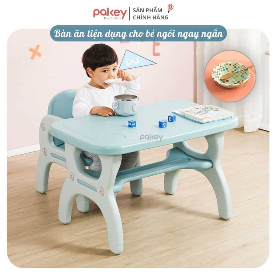 Bé trai ngồi học và ăn trên bàn ghế nhựa màu xanh pastel