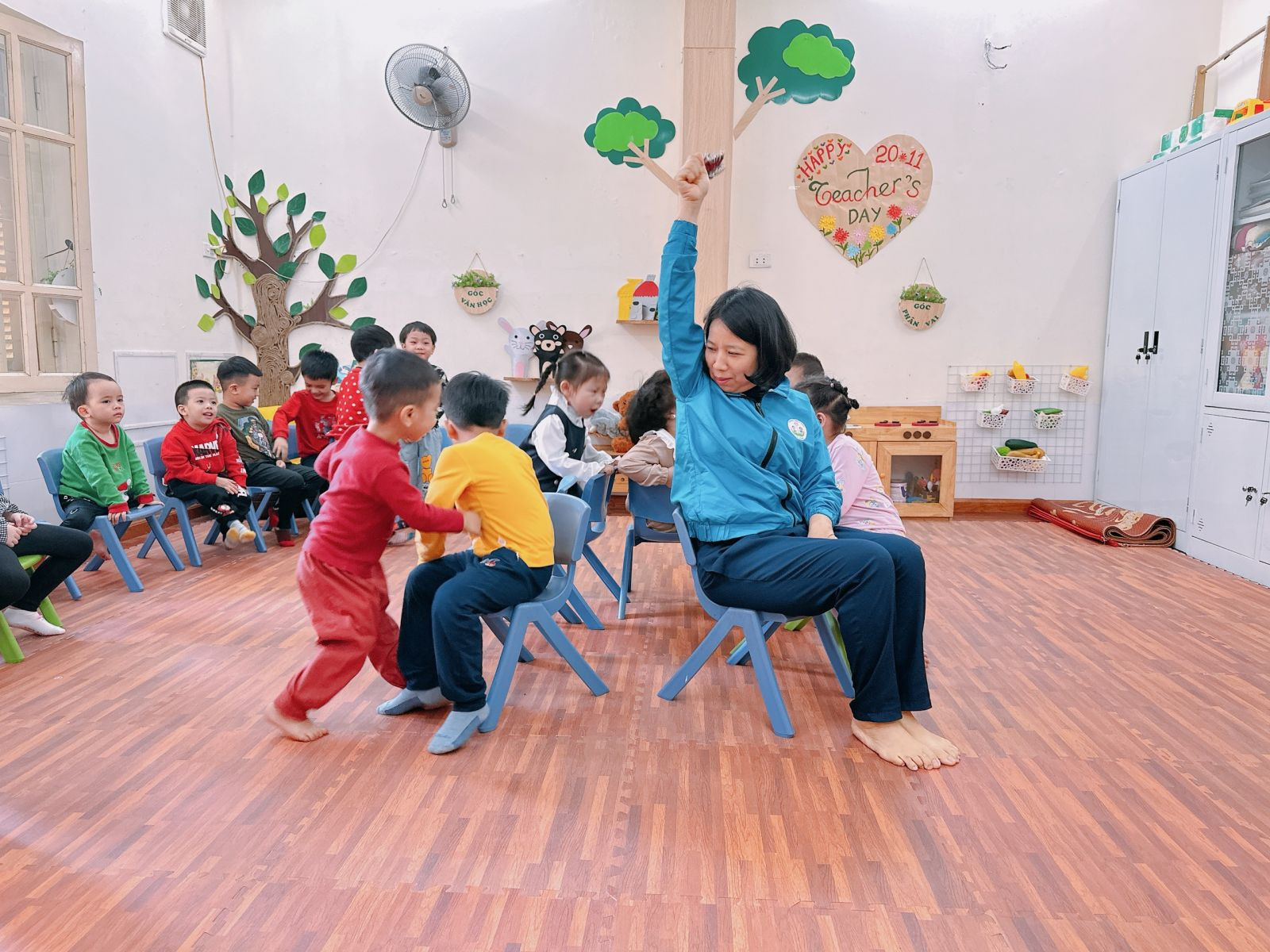 Các em nhỏ đang tập trung lắng nghe hướng dẫn chơi trò chơi ngồi ghế
