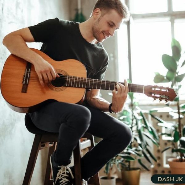 Dáng nam ngồi chơi đàn guitar đầy cuốn hút