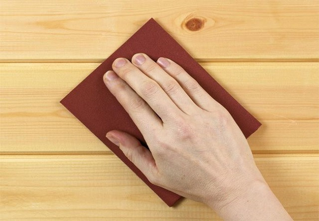 Dùng giấy nhám mịn để làm sạch và đánh bóng bề mặt bàn ghế gỗ trước khi đánh vecni