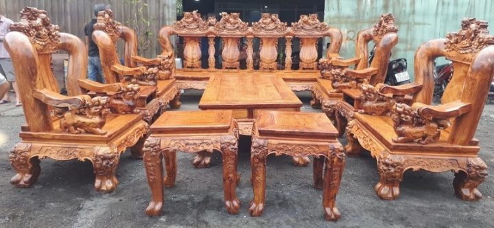 Hình ảnh bộ bàn ghế gỗ đục nghê đỉnh bằng gỗ gõ đỏ, với các đường nét chạm khắc tinh xảo