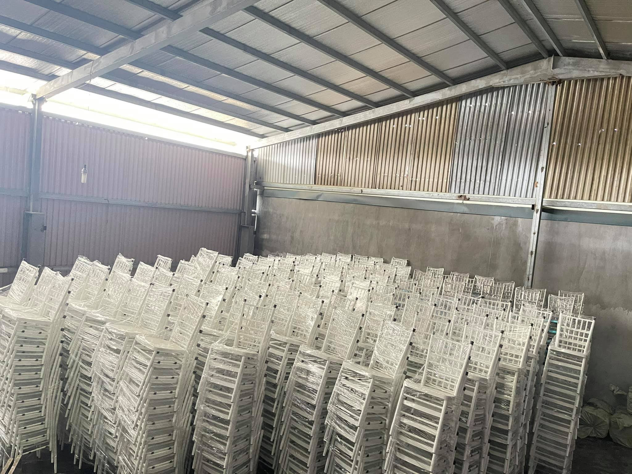 Hình ảnh ghế nhựa màu trắng số lượng lớn tại xưởng sản xuất, đảm bảo chất lượng.