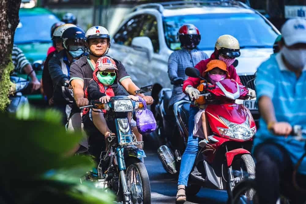 Hình ảnh một em bé ngồi trên ghế ngồi trước xe máy cho bé, được thiết kế chắc chắn với dây đai an toàn, thể hiện sự thoải mái và an toàn