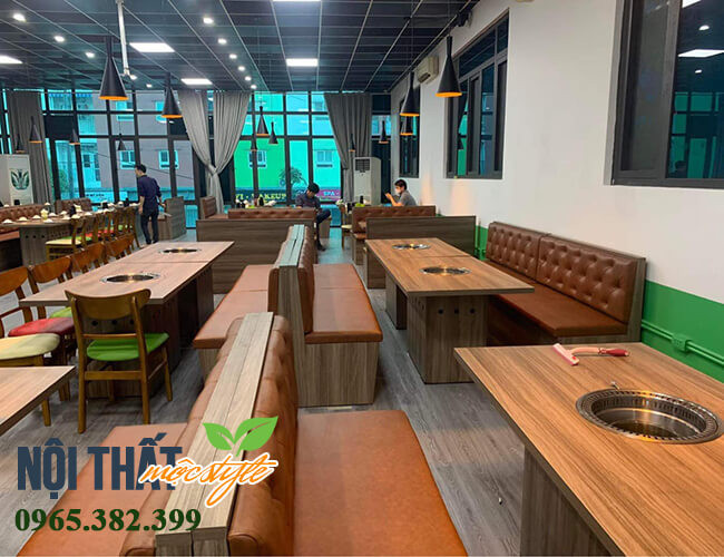 Không gian nhà hàng lẩu nướng hiện đại với bàn ghế băng dài và đèn trang trí lung linh.