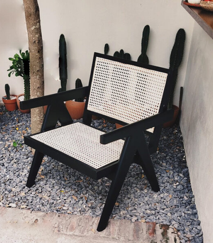 Một chiếc ghế gỗ mây tựa lưng được đan thủ công, mang lại cảm giác thoải mái