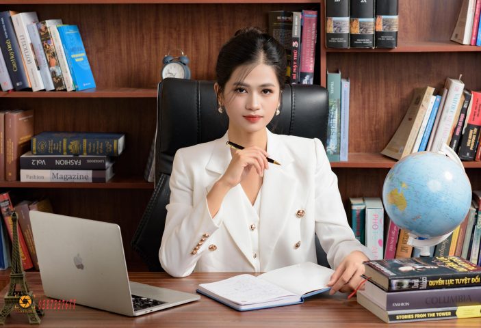Người đàn ông doanh nhân đang ngồi làm việc tại bàn, tạo dáng chụp ảnh tự tin