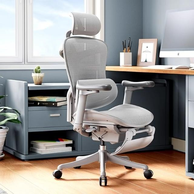 Người phụ nữ đang làm việc trên máy tính với một chiếc ghế công thái học hiện đại, có các đường cong hỗ trợ lưng và tay vịn điều chỉnh được