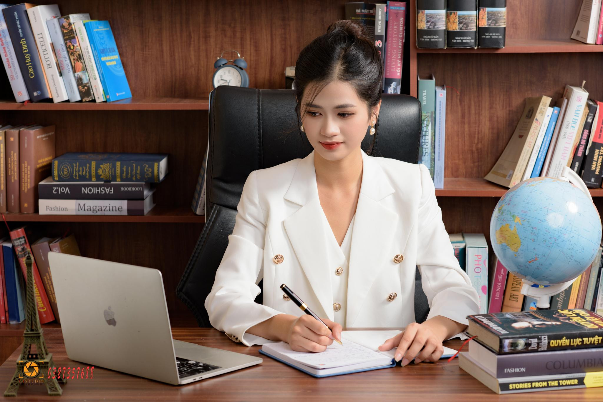 Nữ doanh nhân tạo dáng ngồi bàn làm việc, tươi tắn và năng động