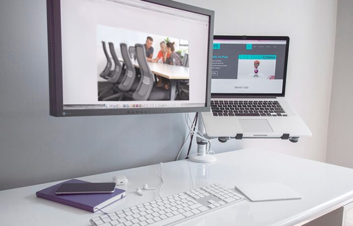 Setup bàn làm việc công thái học với màn hình đặt đúng tầm mắt, ghế gaming và phụ kiện.