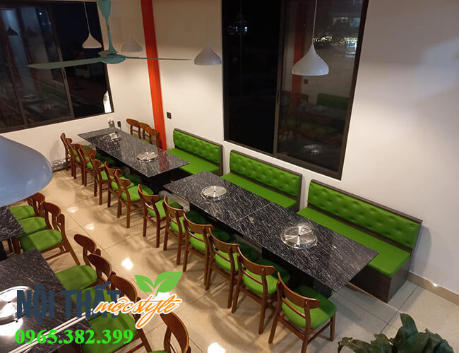 Thiết kế bàn ghế lẩu nướng với ghế băng dài liền tường và đệm xanh nõn chuối, tạo không gian hài hòa.