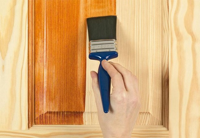 Thợ đang phủ lớp vecni mỏng đều lên bề mặt bàn ghế gỗ theo thớ vân tự nhiên