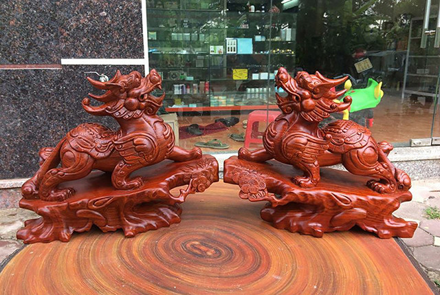 Tượng Tỳ Hưu bằng gỗ mun đặt trên bàn làm việc mang lại tài lộc cho người mệnh Hỏa