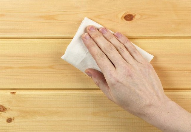 Vệ sinh kỹ lưỡng bề mặt bàn ghế gỗ bằng vải ẩm, đảm bảo sạch bụi trước khi phủ vecni