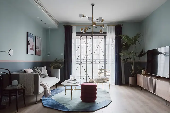 Một Cửa Sổ Lớn Mang Lại Ánh Sáng Tự Nhiên Cho Phòng Khách Màu Xanh Lam Và Màu Hồng Tương Phản. Chậu Cây Xanh Tốt Tạo Điểm Nhấn Sinh Động, Tràn Đầy Sức Sống.