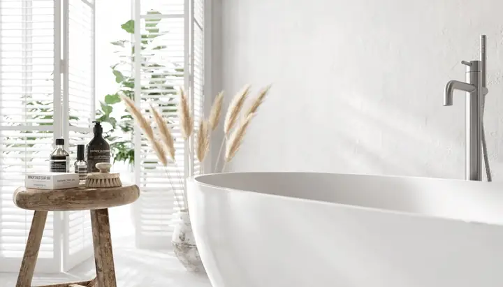 Một chiếc gương thủ công tô điểm cho khu vực phía trên một đơn vị vanity bê tông trắng.