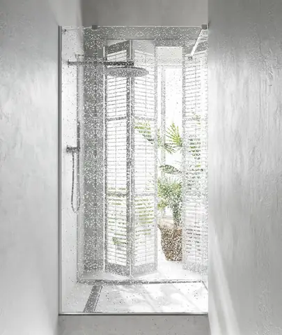 Một chiếc gương thủ công tô điểm cho khu vực phía trên một đơn vị vanity bê tông trắng.